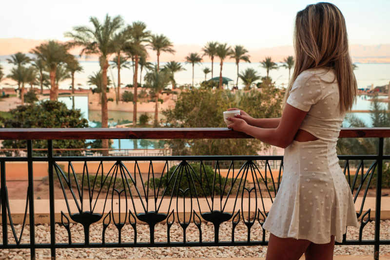 a girl stands in the balcony of mosaique's room and a breakfast with a view to Red Sea