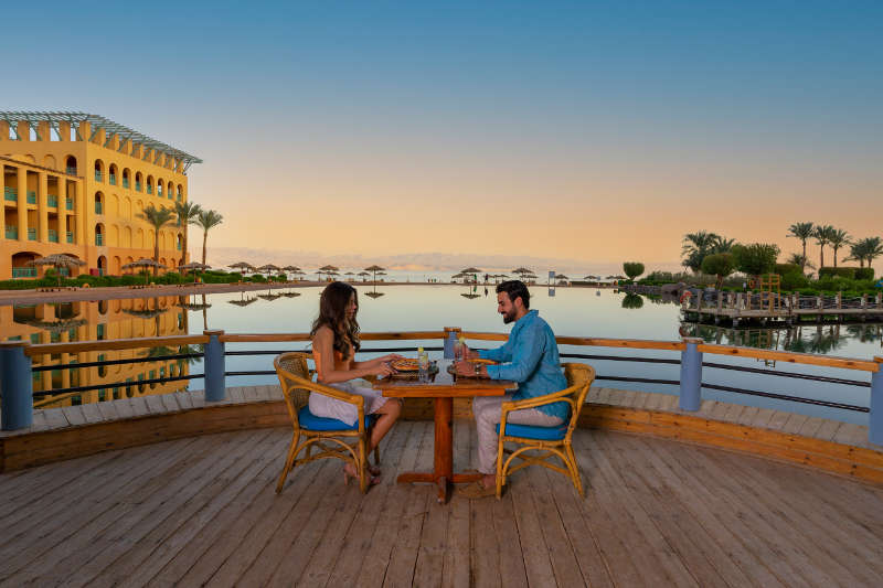A couple enjoys the scenery of Strand Resort in Taba Heights during their meal in the lagoon restaurant