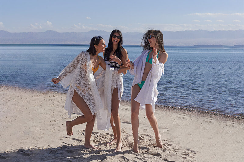 3 girls walking by the beach in a swimsuit at taba heights sinai
