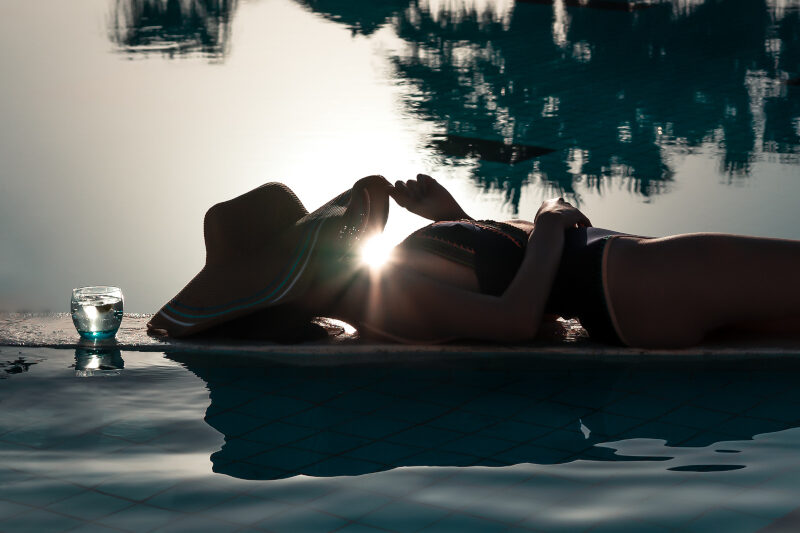 a woman on the pool by sunset wearing a hat in taba heights