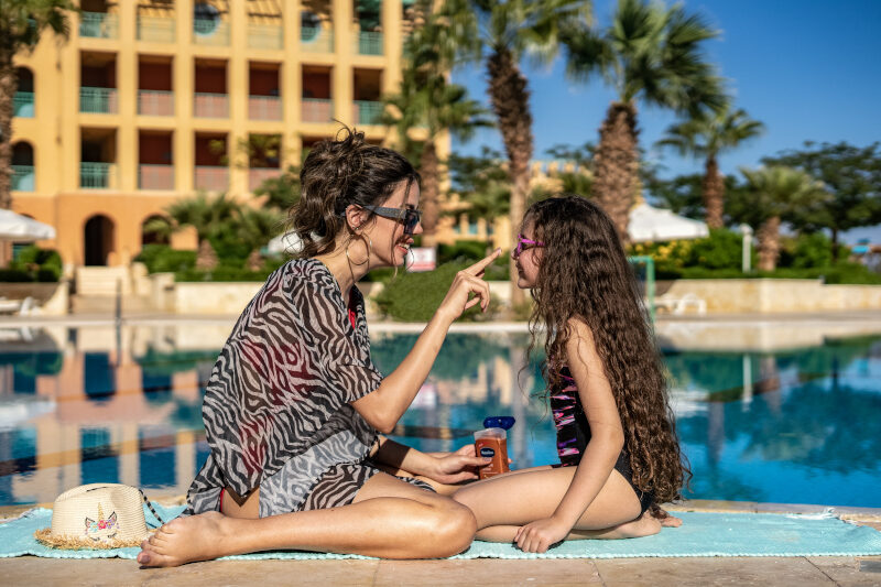 a mother and her daughter applying sunscreen on the pool of taba heights