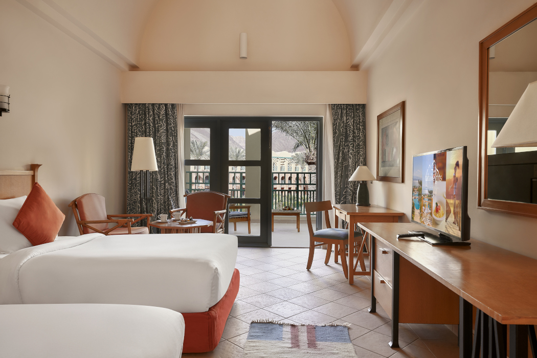 twin beds, a desk mirror and a terrace overlooking the mountain at strand hotels taba heights