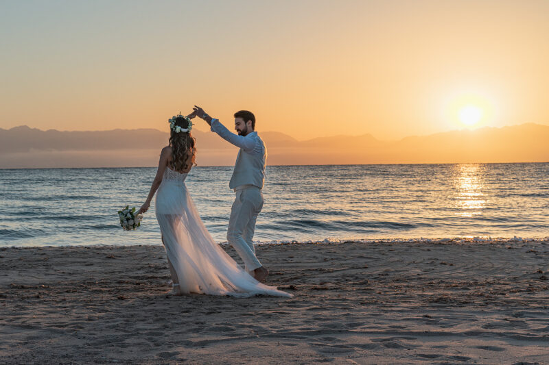 a man and a woman in their wedding gowns in taba on the beach
